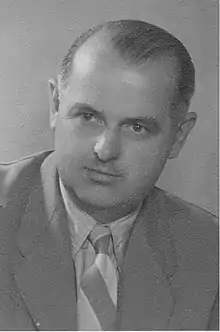 A man wearing a suit, shirt and tie.