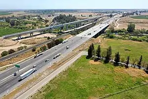 The same viaduct completed in April 2021. Adjacent are the SR 99 freeway and, between them, a single-track railroad line which is used for freight.