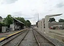 A bus platform and canopy under construction next to a railway line