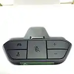 Xbox One Stereo Headset Adapter, a black plastic attachment that plugs into the bottom of the Xbox One Wireless Controller and provides a standard 3.5&nbsp;mm stereo headset jack with microphone contact. The adapter itself is roughly trapezoidal and has five buttons on its face; two buttons on the left to balance audio output between in-game chat (bottom) and game (top); a large center button to mute the chat microphone; and two buttons on the right to increase (top) or decrease (bottom) overall volume.