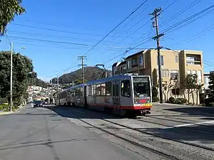 A train passing the future site of Ulloa and 14th Avenue station in February 2019