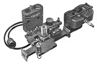 Transmitter assembly of a 20&nbsp;kW, 9.375&nbsp;GHz air traffic control radar, 1947.  The magnetron tube mounted between two magnets (right) produces microwaves which pass from the aperture (left) into a waveguide which conducts them to the dish antenna.
