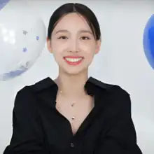 Nayeon smiling while looking at the camera