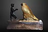 Taharqa offering wine jars to Falcon-god Hemen; 690–664 BC; bronze, greywacke, gold and wood; length: 26&nbsp;cm, height: 19.7&nbsp;cm, width: 10.3&nbsp;cm; Louvre