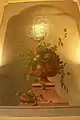 Flowers and fruits in a vase with watermelon (above the hearth)