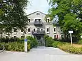 1906/07, Friedrich von Thiersch built a youthfully designed hipped roof house in the Mandlstraße 1, in front of it is a 1907 designed fountain from Mathias Gasteiger with two youthful figures.
