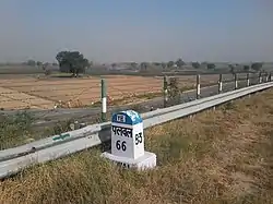 The milestone is made in front of the way of turning entrance into village road.