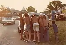 Photo avec 6 hommes qui poussent une camionnette.