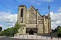 Façade d'une église avec son clocher sur le côté gauche.