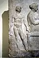 Relief votif au banquet funèbre. Jeune esclave nu tenant une œnochoé. Athènes Ve&nbsp;siècle. Musée archéologique d'Athènes
