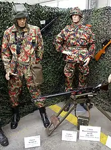 Modèles 1973 (Kafaz 73) de l'uniforme Alpenflage : tankiste avec le Kombi et fantassin avec l'ensemble complet (couvre-casque, veste et salopette multi-fessiers).