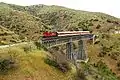 L'A-458 (nouvelle livrée) tractant le train spécial 7510 sur un pont entre Lianokladi et Domokos.