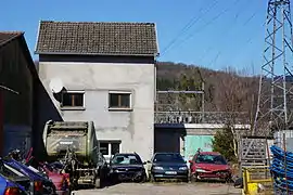 Panneau en bois devant un grillage.