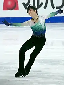 Homme sur une patinoire portant une combinaison de plusieurs nuances de bleues.