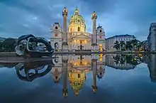 Une église monumentale avec une sculpture métaphysique entre chien et loup.