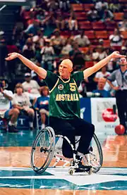 joueur de handibasket, les bras en forme de V en l'air.