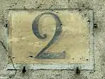 Numéro peint en noir sur fond ocre, conformément à la réglementation de 1805 pour les rues perpendiculaires à la Seine.