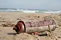 Cannette aérosol échouée sur une plage.