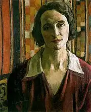 Portrait en buste d'une femme de face, l'air calme, la bouche large, les cheveux bruns mi-longs et légèrement crantés