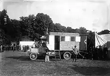 Photographie en noir et blanc d'une ambulance vue de côté dans une clairière.