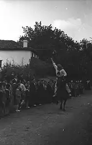 Vue d’un cavalier qui cherche à attraper un canard pendu par les pattes à une corde tendue à l’horizontale.