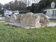 Vue d'un vestige de monument antique (canal d'aqueduc) exposé au milieu d'une pelouse.