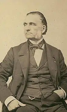 Photographie sépia d’un homme d'une soixantaine d'années, visage tourné de trois quarts vers la droite