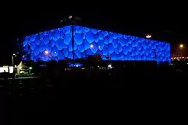 Centre national de natation de Pékin en nocturne. PTW Architects, 2007. Paroi en ETFE.