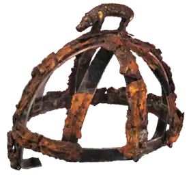 les restes rouillés d'un casque surmontés d'une figurine de sanglier