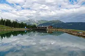 Bergeralm&nbsp;(de), avec sa réserve d'eau pour les canons à neige et un restaurant à l'arrière plan, à Steinach am Brenner. Aout 2021.