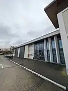 Bibliothèque municipale Pénélope Bagieu (à droite), salle communale (à gauche rideaux fermés)