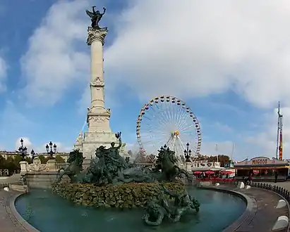Colonne du monument aux Girondins et installations de la foire aux plaisirs.
