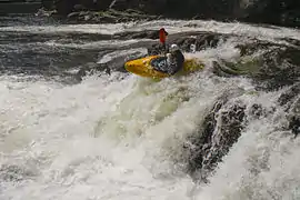 Derrière la chute d’eau.
