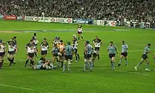 Joueur des deux équipes, lors d'un arrêt de jeu, deux hommes se relevant.