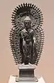 Bouddha debout avec halo et mandorle à rayons. Statuette portative. Gandhara, v. fin VIe&nbsp;siècle. Laiton, H. 33,7&nbsp;cm. Met.