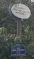 Plaque de rue avec bulle "quand-est-ce qu'on mange ?"