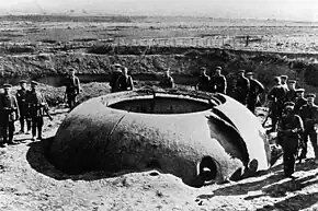 Soldats allemands posant autour de la tourelle Mougin du fort de Boussois (lors du siège de Maubeuge), décalottée en 1914 par les obus de 210&nbsp;mm.