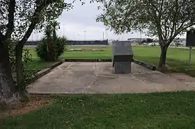 Vue d'un bloc de pierre taillée, en bordure d'un stade.