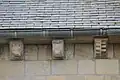 Vue de la partie supérieure du mur avec quelques modillons.