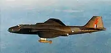 Vue latérale d'un jet bimoteur militaire camouflé en vol d'altitude
