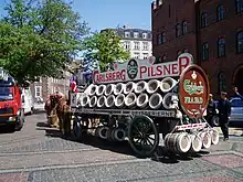 Arrière d'un gros chariot chargé de tonneaux.