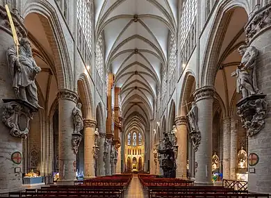 Vue de la nef de la cathédrale bordée de colonnes cylindriques supportant les 12 statues des apôtres