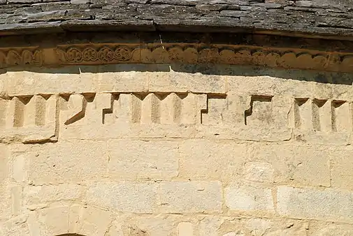 Frise de dents d'engrenagemêlée de motifs inspirés de la « grecque ».