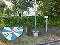 Croix de chemin et blason dans le bourg.