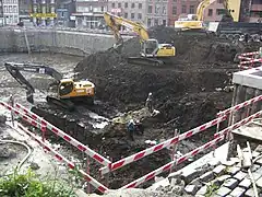 Dégagement de la contrescarpe par les archéologues au milieu des engins de chantier.