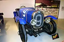 Photo d'une voiture bleue à carrosserie ouverte exposée dans un musée.