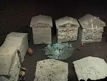 Vestiges du bouclier de bronze entre les urnes.