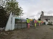Photographie des grilles d'entrée du parc laissées à l'abandon.