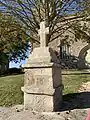 Croix latine et son support en granit à gauche de l'escalier sud à l'extérieur de l'église.