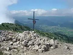 Village vu d'un point culminant avec une croix en premier plan.